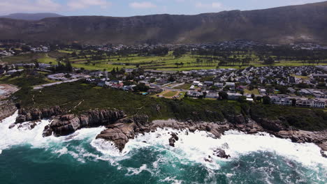 drone pan reveals epic setting of hermanus between mountain and ocean