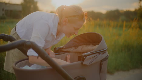mother with baby stroller at sunset