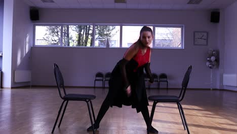 professional female dancer dances around two chairs