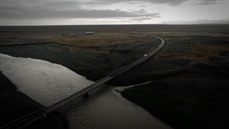 aerial ring road iceland, car driving over bridge and river, flying over nature mountain cinematic view