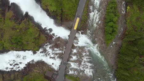 truck driving over bridge in norwegian highlands, latefossen waterfall, aerial