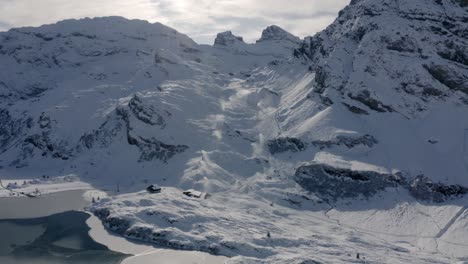 slow sideways aerial view of snow slope being snowed on by snow cannons at trübsee near engelberg in switzerland
