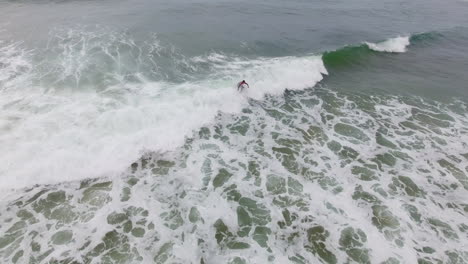 cinematic flying of surfers surfing along coast of east london south africa aerial