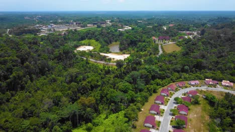 amazing cinematic 4k residential drone footage after deforestation issue consists of many homes, road, trees, lake and infrastructure in the middle of tropical forest located in riau, indonesia