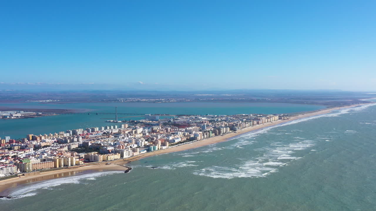 Ampia ripresa aerea di Cadice, Spagna: grande spiaggia sabbiosa, giornata di sole, Cattedrale e porto