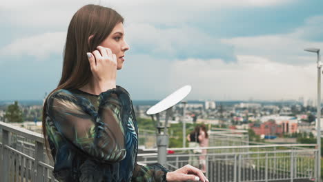 Tranquil-woman-in-cute-dress-enjoys-large-city-view-closeup