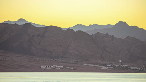 Timelapse-shot-of-sunrise-over-barren-mountain-range-at-golden-bay-in-Malta-during-morning-time