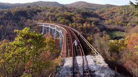 hombre tratando de caminar sobre un puente ferroviario por las montañas voras en grecia