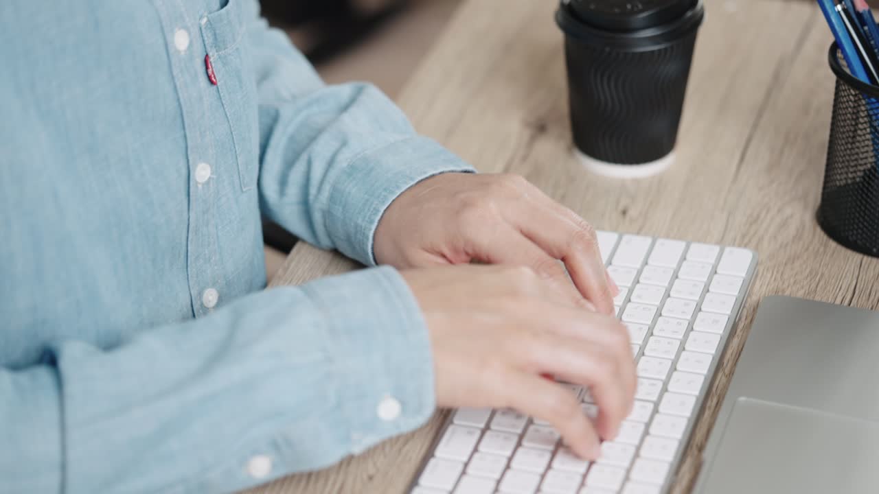 mano de cerca de una mujer de negocios escribiendo teclado computadora de escritorio en la oficina de escritorio