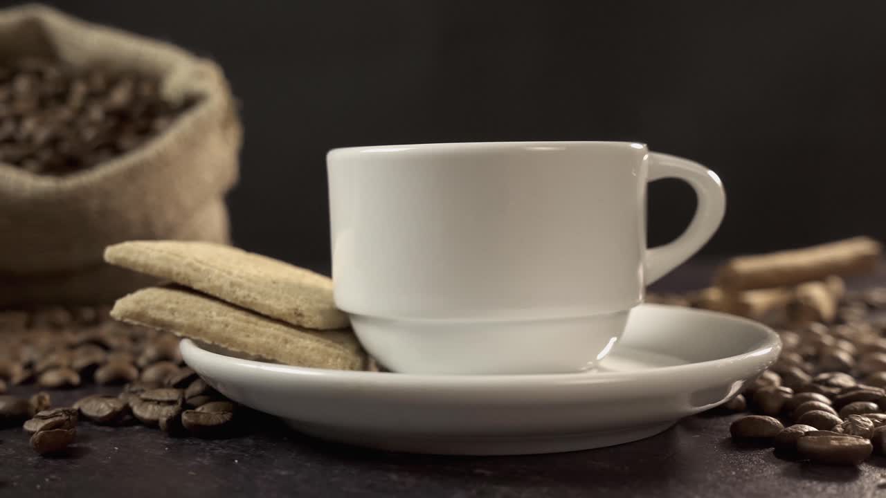 白いカップとクッキーを添えた焙煎コーヒー豆