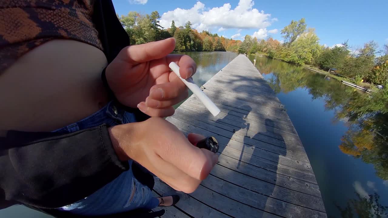 담배에 불을 붙이려는 젊은 여성