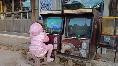 girl playing vintage arcade game in korea