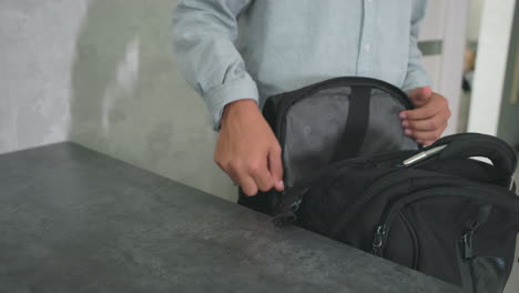 girl boy in casual wear packing notebooks water bottles lunchboxes into backpacks on kitchen counter near fridge before school day morning routine siblings preparing healthy lunch and supplies for classroom