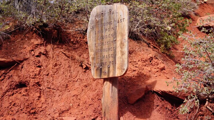 Sign asking hikers to stay on the trail to minimize environmental damage to the natural resources