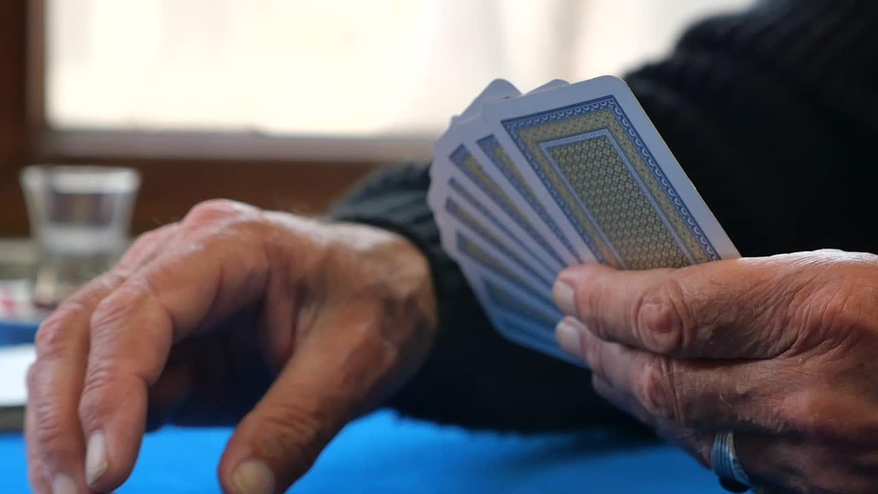 Detailní záběr rukou držících hrací karty