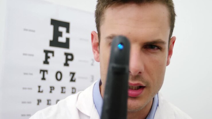 Close-up of optometrist looking through ophthalmoscope