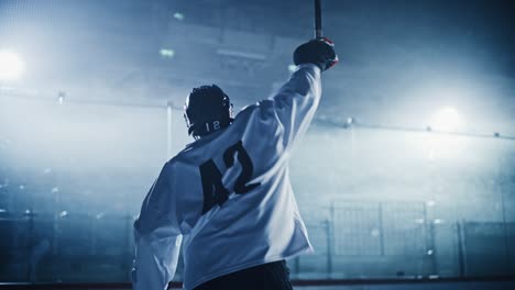 ice hockey game: professional player celebrating victory on rink, raising arms. joyful young athlete became a champion, through effort and determination.