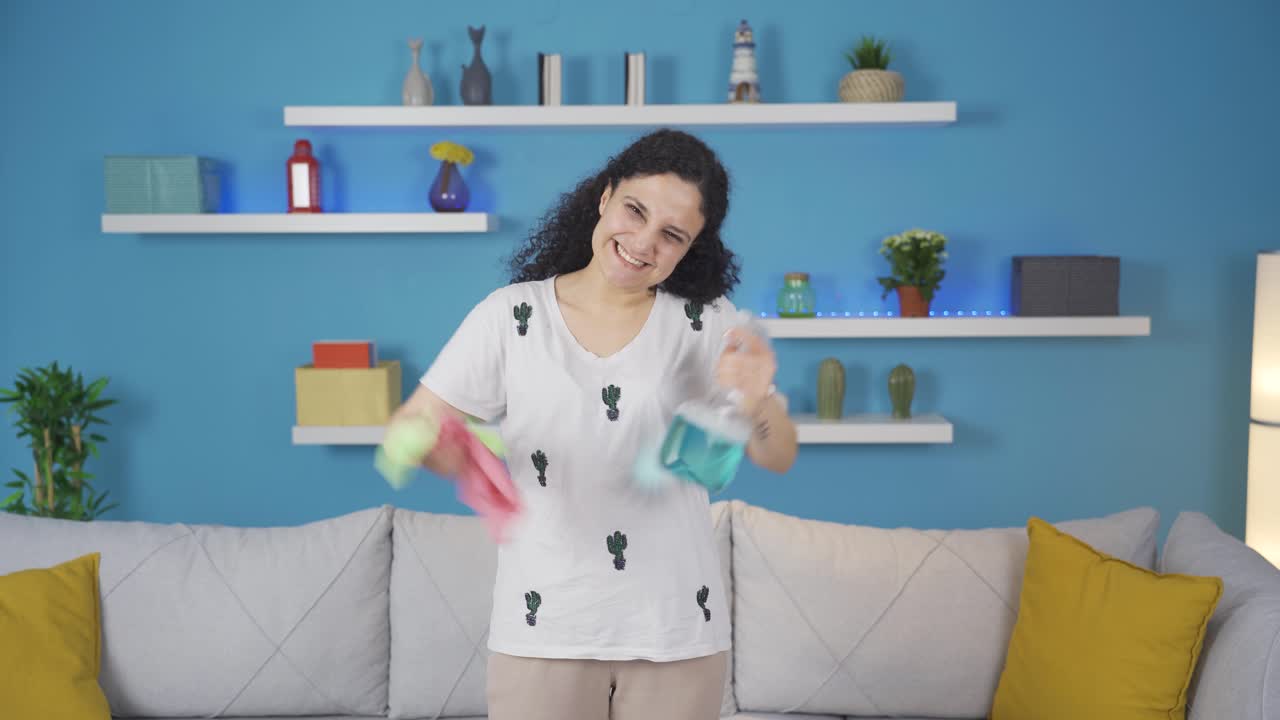 청소 용품을 가지고 카메라를 쳐다보고 있습니다.