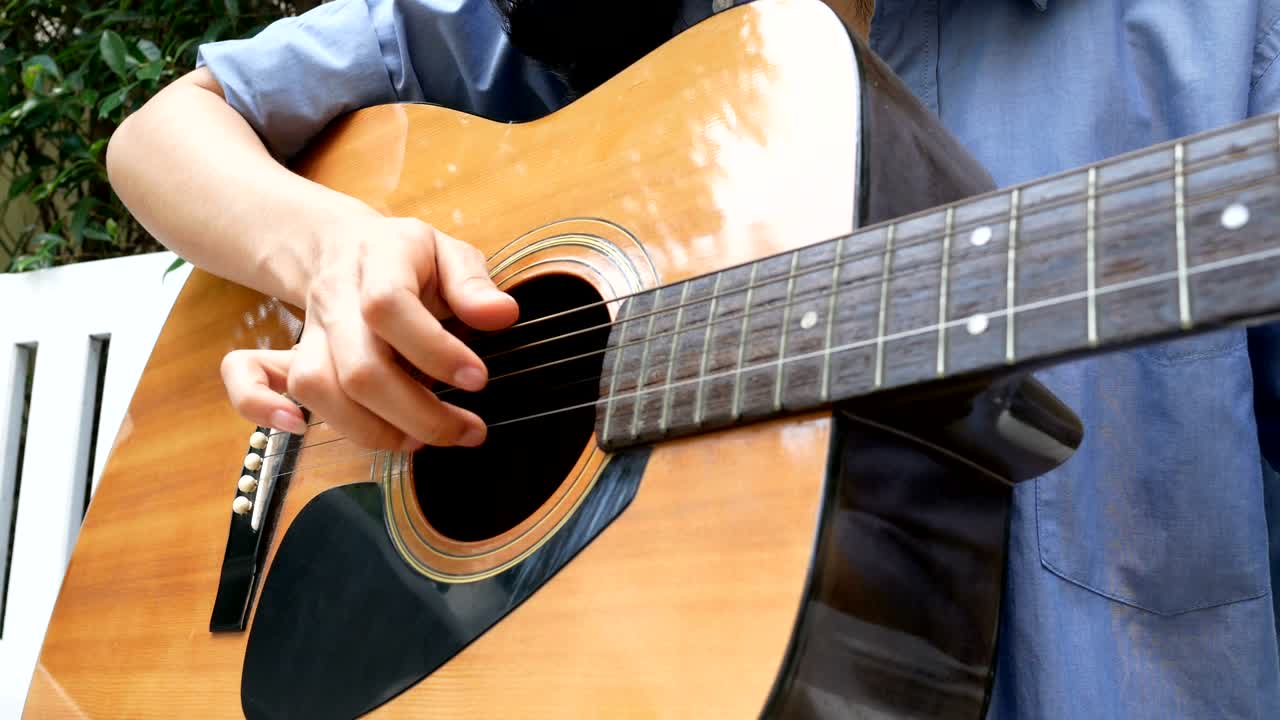 집에서 미소 짓고 기타를 연주하는 여자.