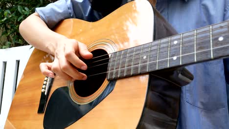 mujer tocando la guitarra con una sonrisa en casa.