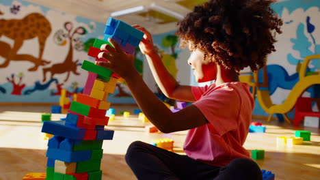 child playing with building blocks in playroom