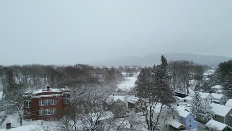 drone rises above home and apartment skyline to reveal frozen aftermath of large noreaster storm