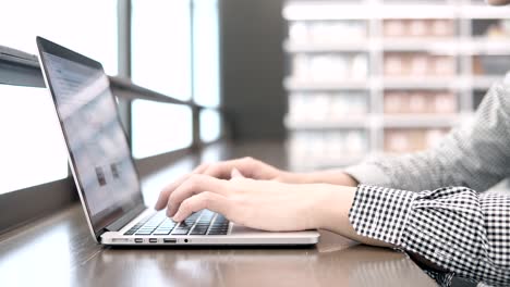 asian university student man using laptop computer in college library. young businessman typing on laptop keyboard in working space. freelance lifestyle or educational research concepts