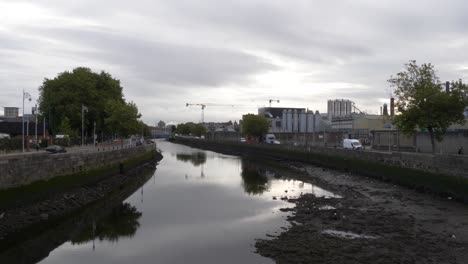 shallow water of liffey river with guinness brewery plant in the background