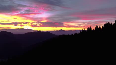 sunrise drone flight in mountainous landscape, colorful cloudy sky