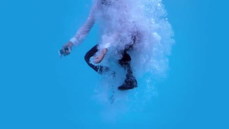 businessman jumping into swimming pool holding smartphone