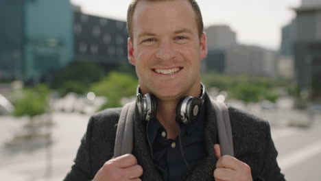 close up portrait of successful young caucasian businessman executive smiling excited at camera looking confident in urban city background