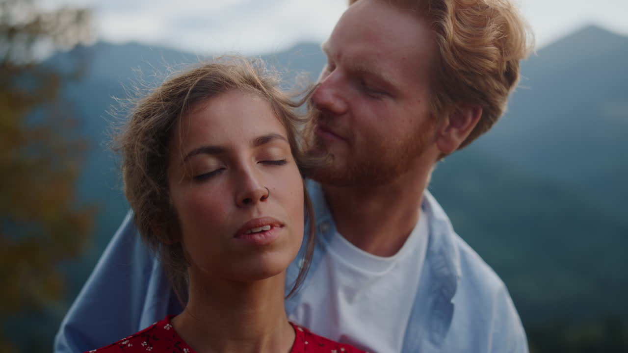 Lovely couple enjoying honey moon in mountains closeup. Lover hugging woman back