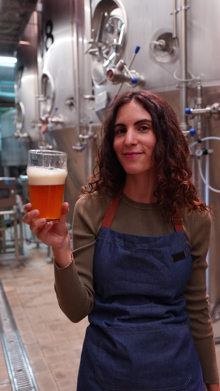 Donna che tiene in mano un bicchiere di birra in un birrificio