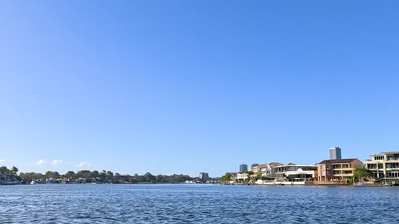 A serene view of waterfront homes against a bright blue sky, capturing the essence of tranquil living.