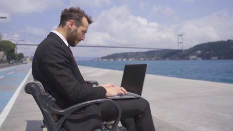 Hombre-Feliz-En-Traje.-él-Está-Trabajando-En-Su-Computadora-Portátil.-Camara-Lenta.