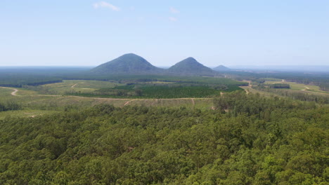 aerial drone view over green glasshouse mountain rural countryside and trees, 4k