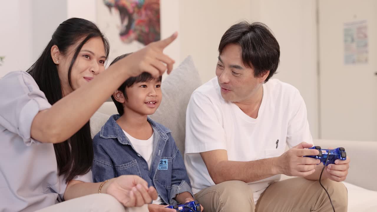 A family enjoys playing video games together on a couch, highlighting joy and togetherness in a bright, cozy setting