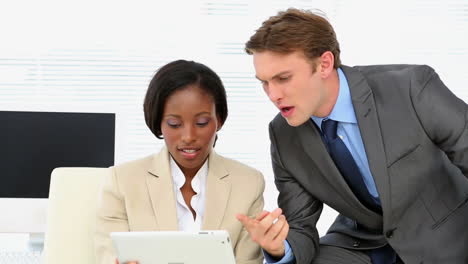 Business-people-talking-together-at-desk-with-tablet