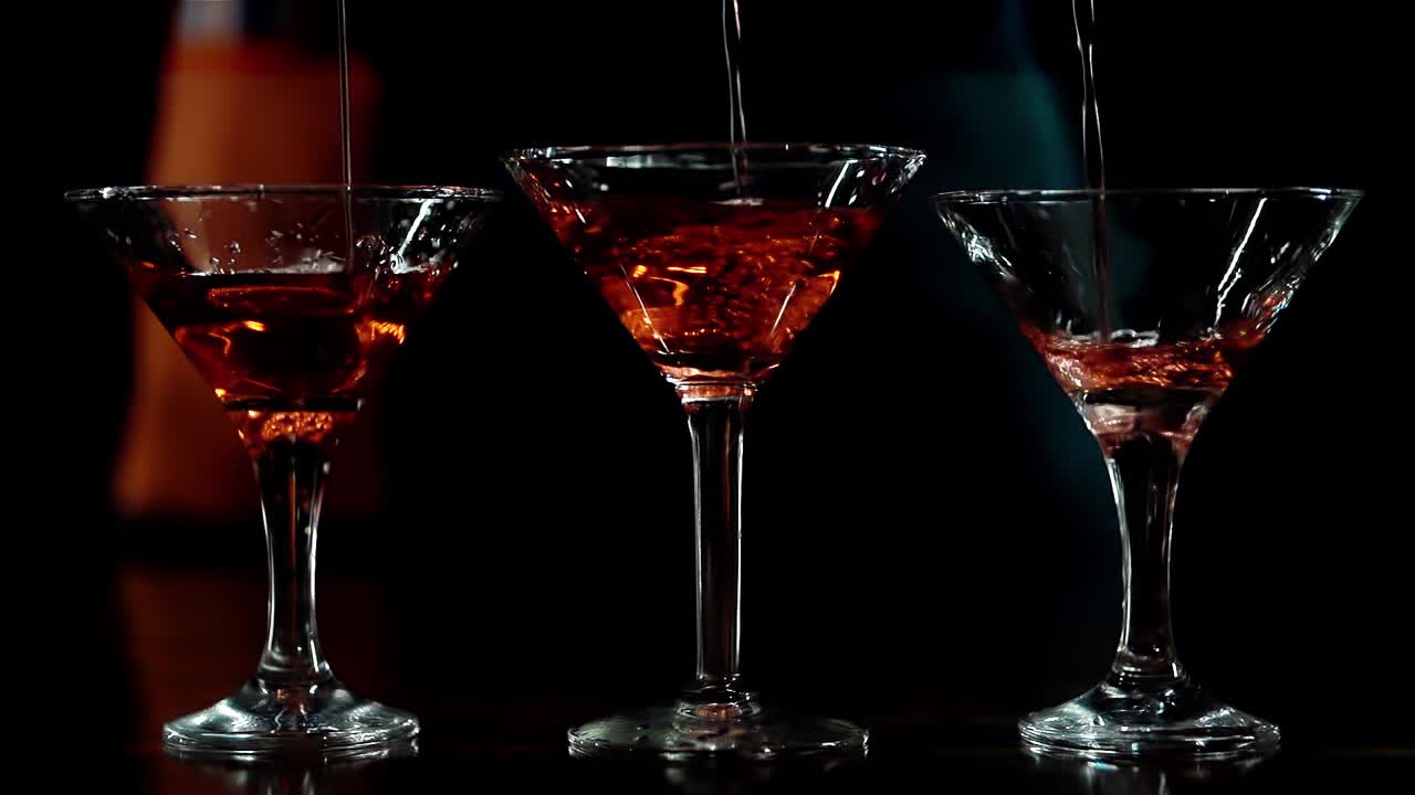 il barista invisibile versa un cocktail rosso.