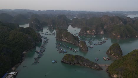 drone shot of group of tropical island cliffs in bright blue water in cat ba and halong bay in northern vietnam