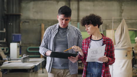 carpenters reviewing blueprints in a workshop