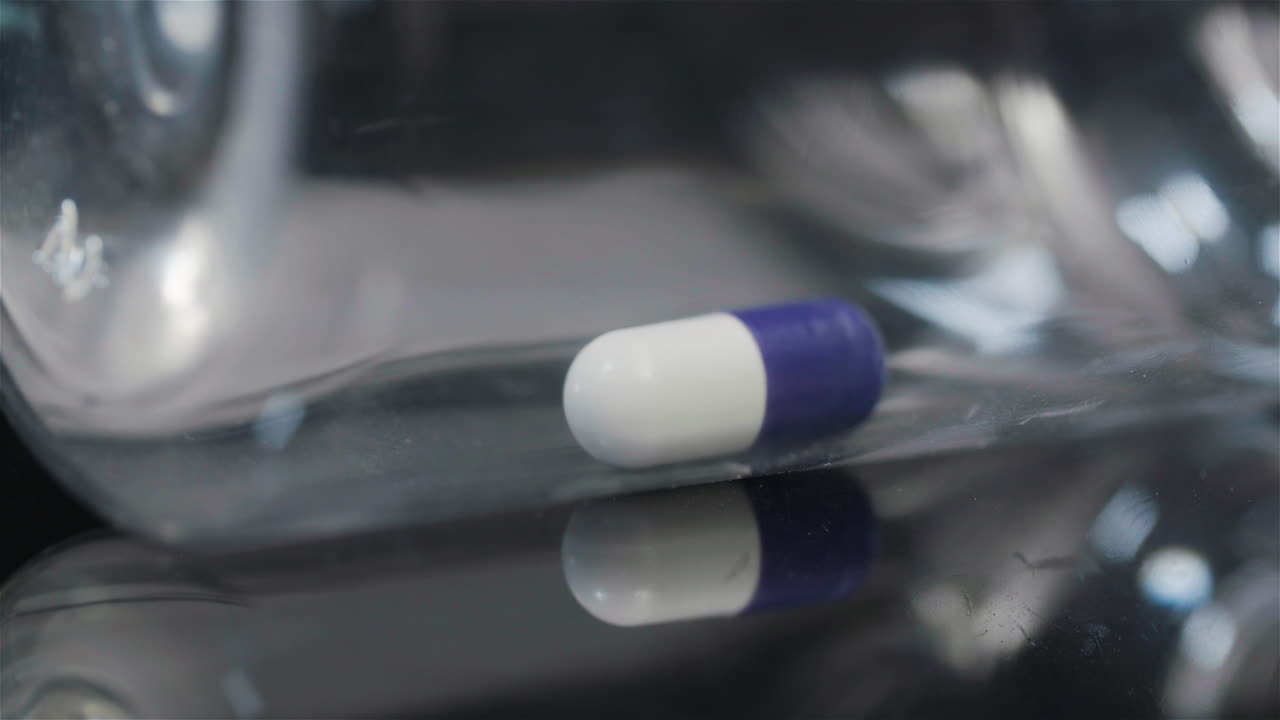 검정색 배경 8에서 회전하는 작은 병의 단일 의료 알약