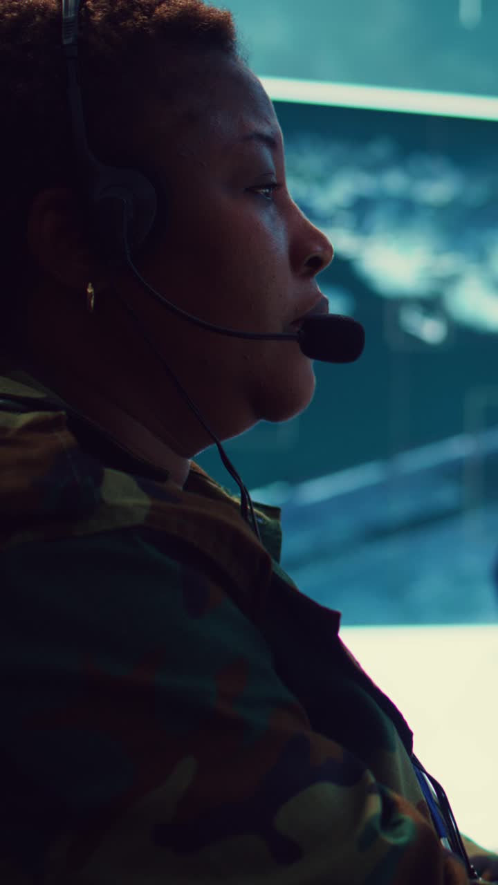 Afroamerikansk kvindelig soldat med headset, der arbejder i kontrolrum