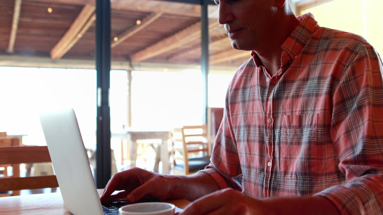 Man using laptop while having coffee 4k