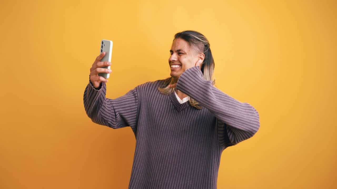 Happy Young Man Taking Selfie and Gesturing with Smartphone