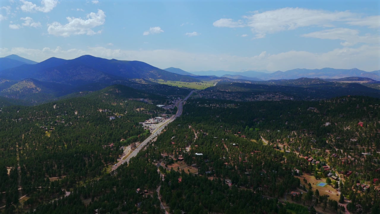 Hiwan Hills, Rodovia 73 74, centro de Evergreen, pequena cidade montanhosa. Vista aérea de drone, Colorado. Carros, Front Range, Montanhas Rochosas. Verão, primavera, manhã/tarde ensolarada/nublada. Espaço aberto, céu azul, movimento para frente.