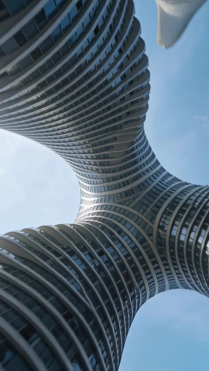 Vídeo vertical: Câmera panorâmica inclinando para cima sob três torres, revelando o núcleo central e as aletas.