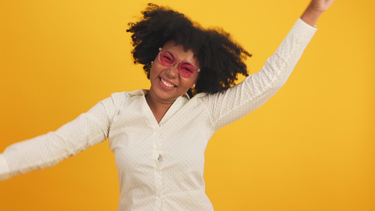 Happy attractive african young woman dancing isolated on yellow background.Cheerful pretty girl happy with tablet notebook online music smiling and moving body follow music with positive.