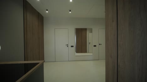 pasillo moderno con iluminación colgante y paneles de madera