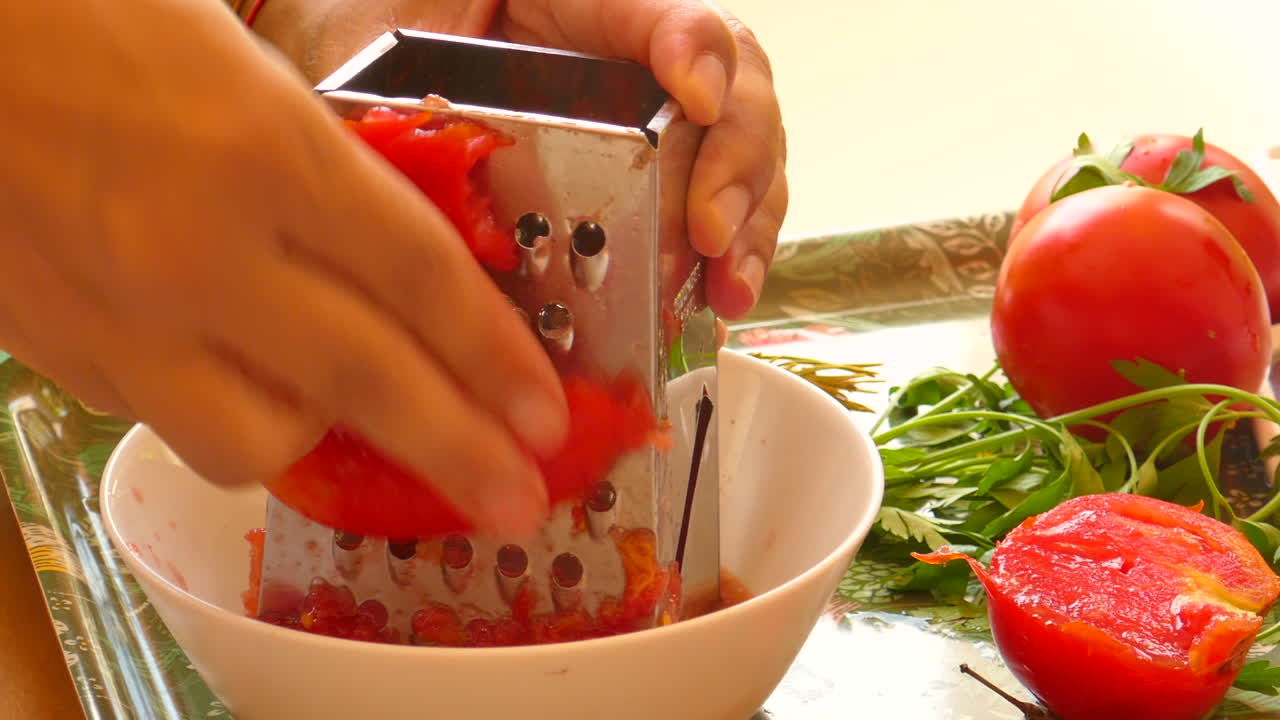 Detail of female hands grated tomato for typical Valencian paella &amp;quot;sofrito